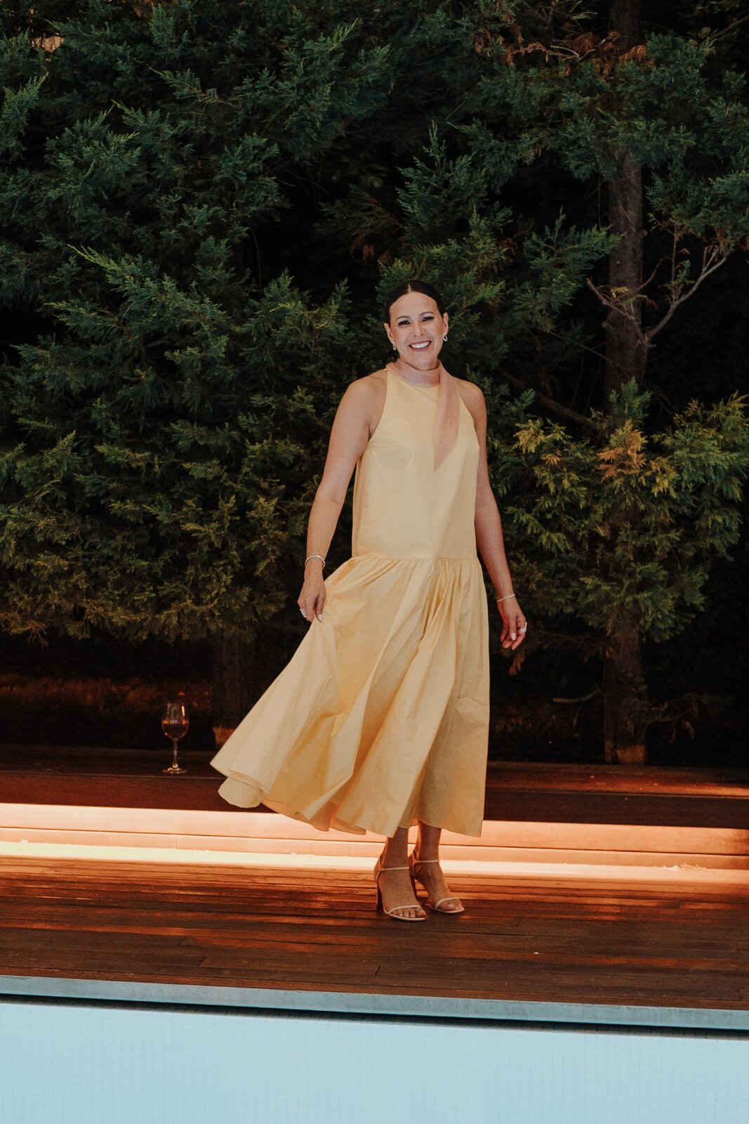Vestido amarillo halter midi con falda fruncida en evento al aire libre